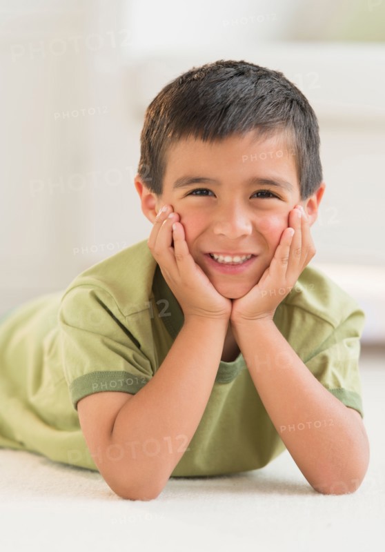 Portrait of boy (6-7) lying on carpet.