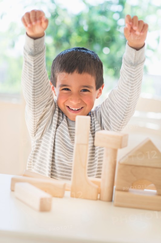 Boy (6-7) playing with toy blocks.