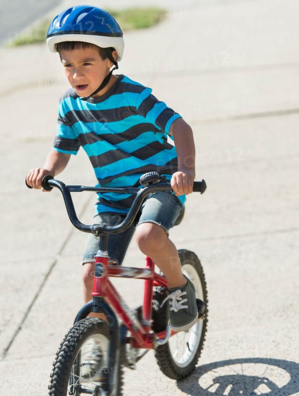 Boy (6-7) riding bicycle.