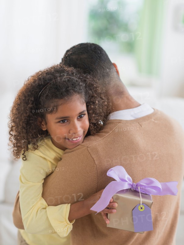 Daughter (6-7) hiding gift for her father behind her back.