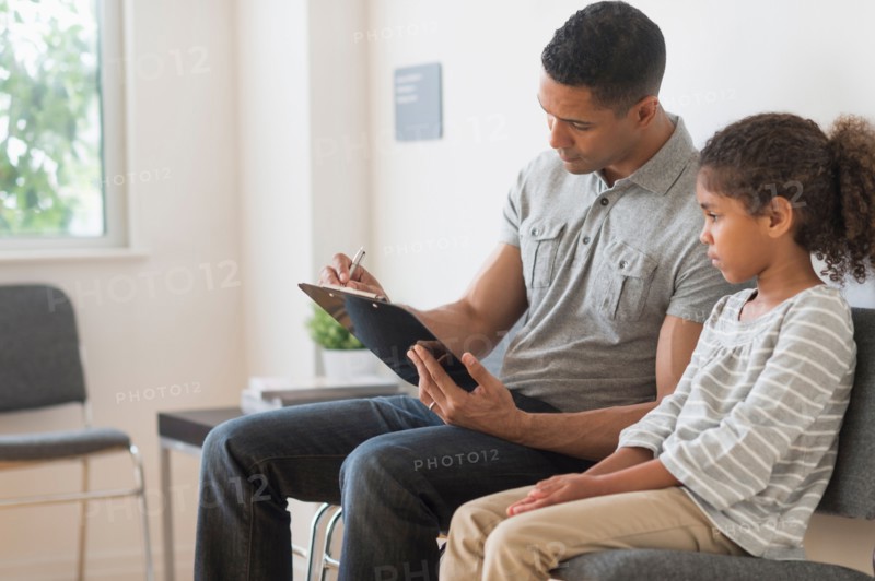 Father with daughter (6-7) waiting for doctor's appointment.