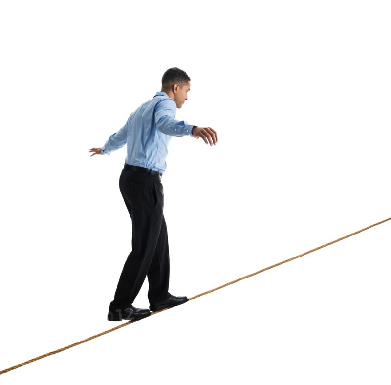 Man balancing on tightrope, studio shot.