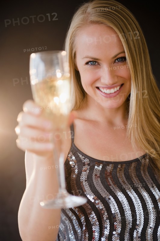 Young woman making toast with champagne