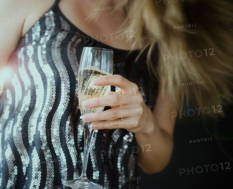 Young woman making toast with champagne