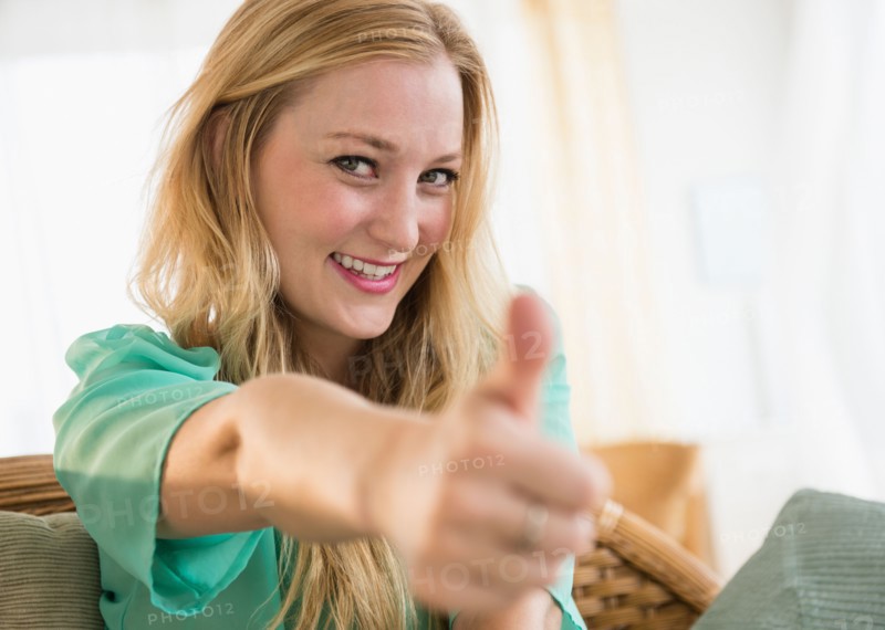 Portrait of young woman with thumbs up