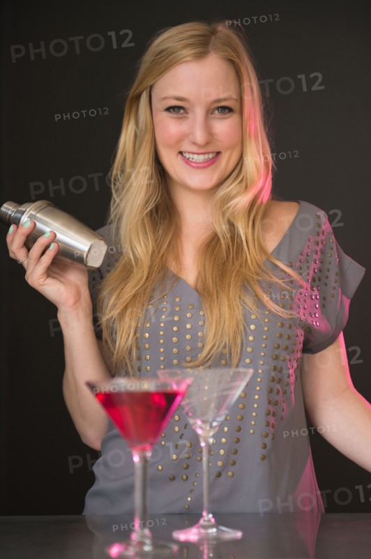 Young woman preparing martini