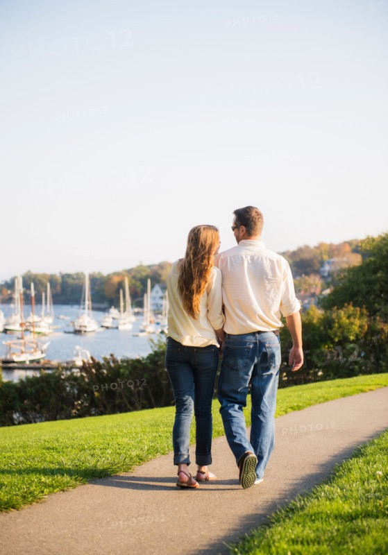 Couple walking with harbor in background