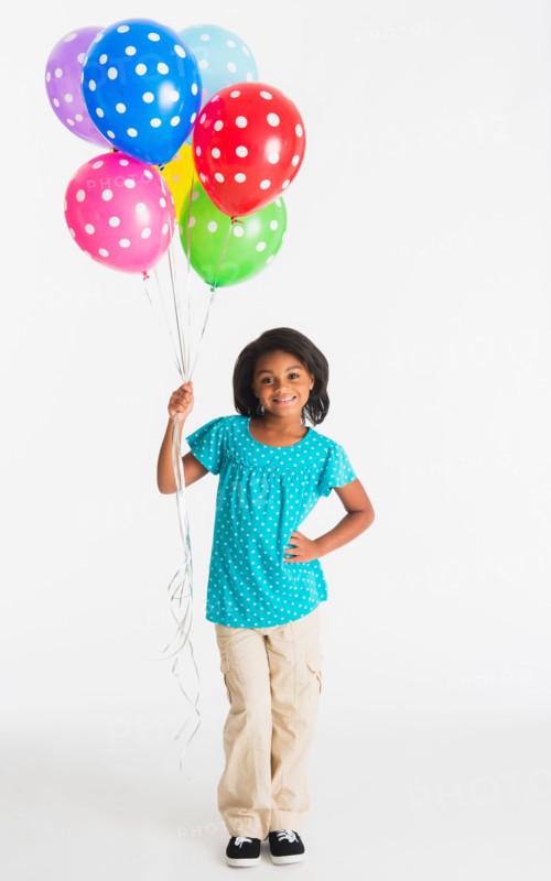 Studio shot of girl (6-7 years) holding colorful balloons