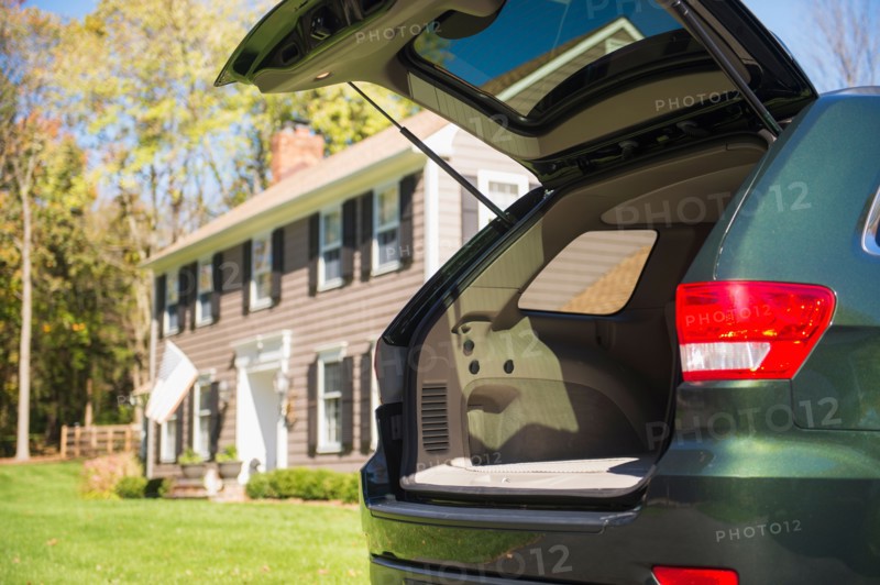 Open car trunk in front of house