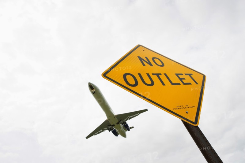 Low angle view of airplane over road sign