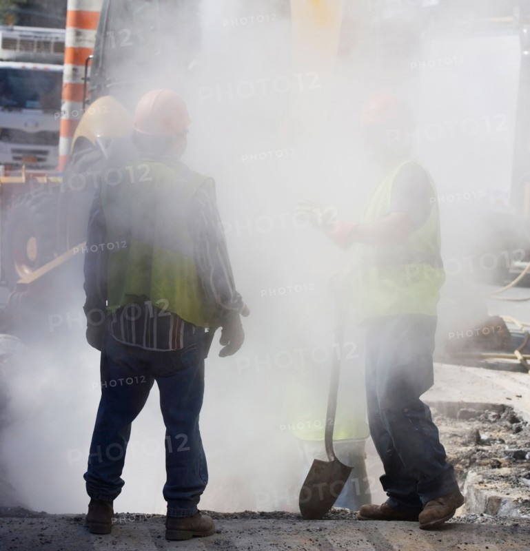 Construction workers digging hole