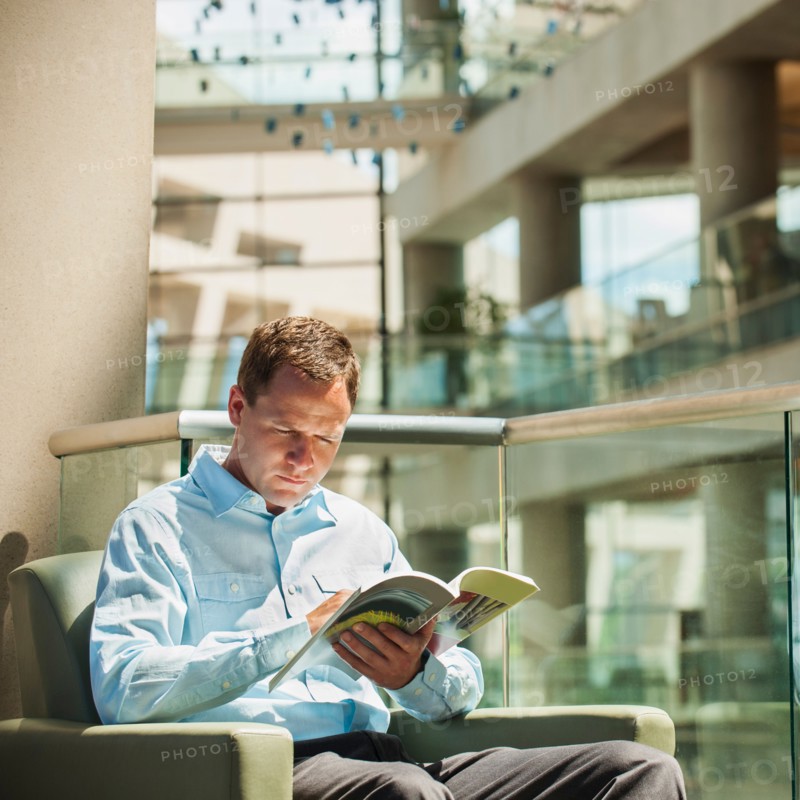 Portrait of man reading in armchair