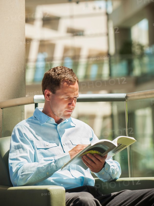 Portrait of man reading in armchair
