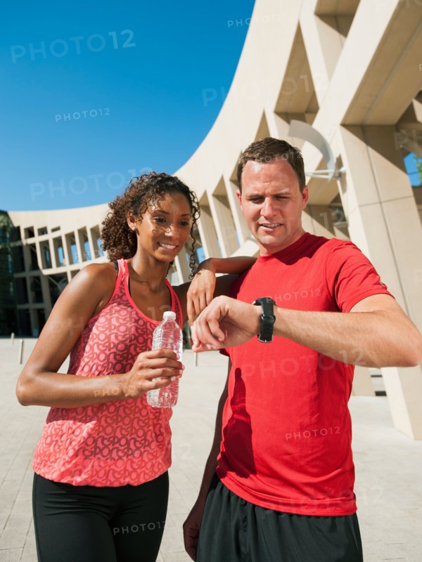 Man and woman checking time after jogging