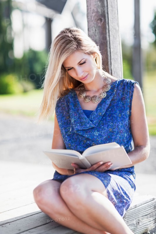 Portrait of woman reading book outdoors