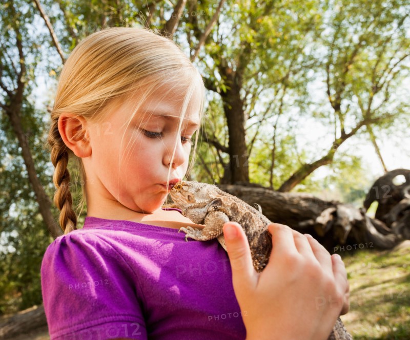 Little girl (4-5) kissing lizard