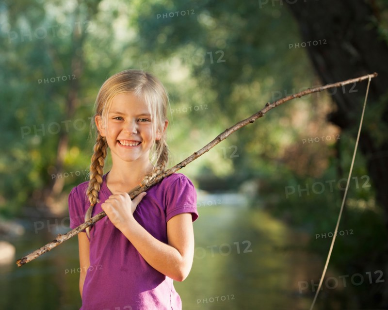 Little girl (4-5) holding wooden stick fishing pole