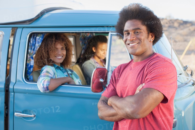 Man in foreground with friends during their road trip