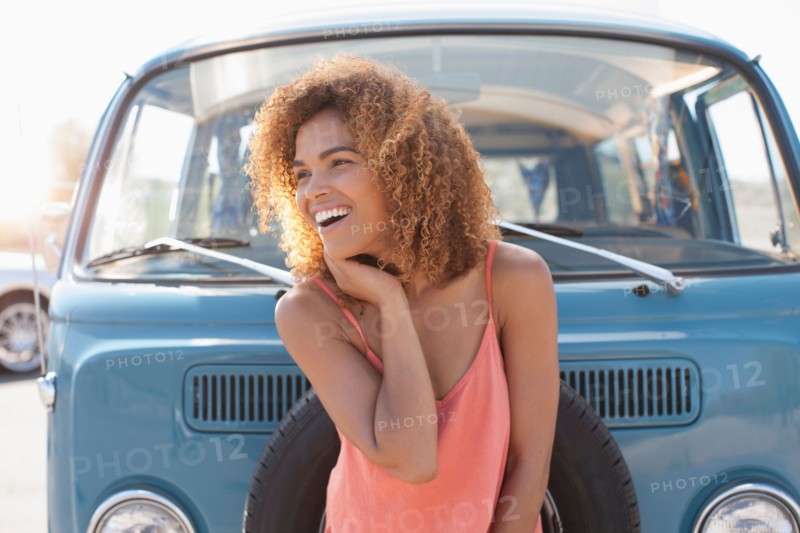 Smiling woman standing in front of van