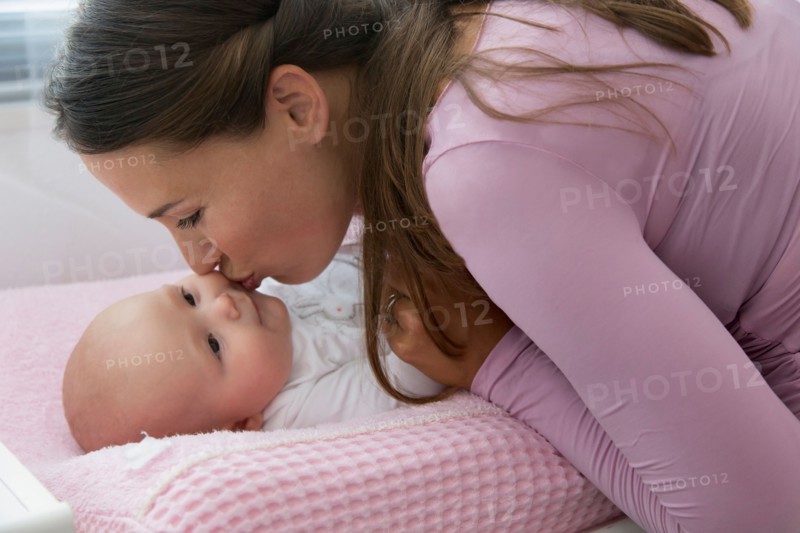 Mother kissing baby daughter (6-11 months)