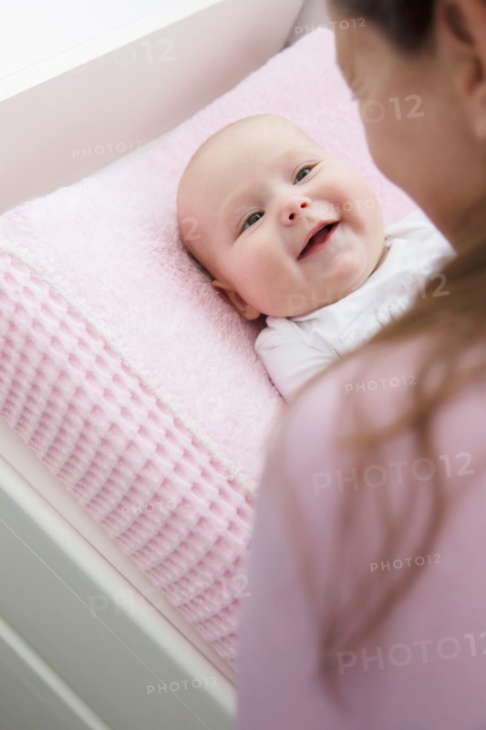 Mother playing with baby daughter (6-11 months)