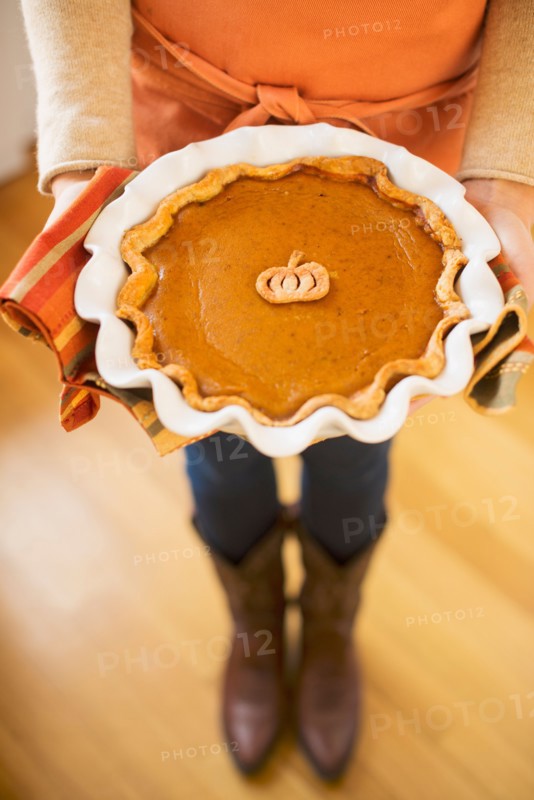 Woman holding pumpkin pie.