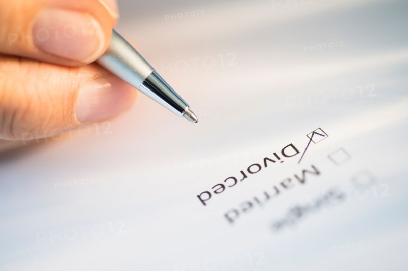 Close-up of hand filling out form.