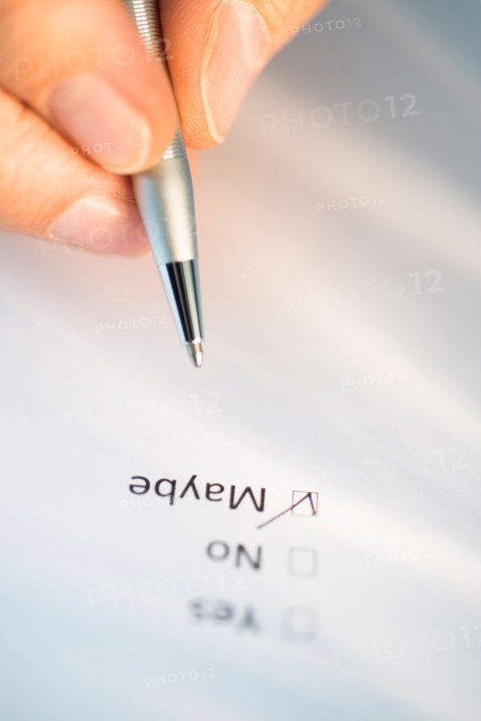 Close-up of hand filling out form.