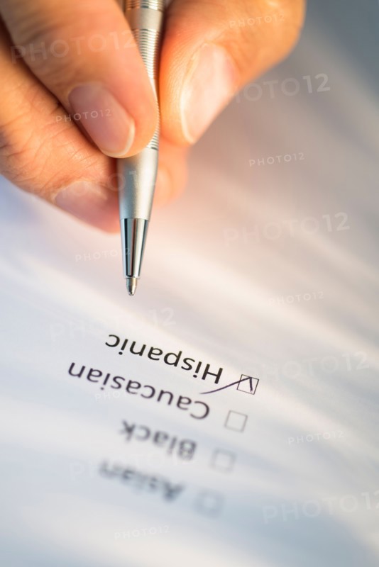 Close-up of hand filling out form.
