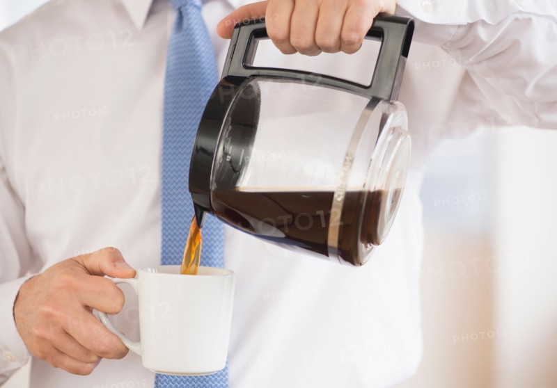 Businessman pouring coffee.