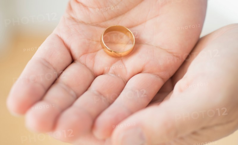Hand holding wedding ring.