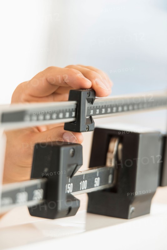 Hand adjusting weight scales.