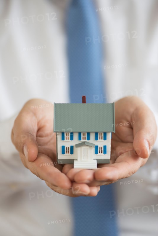 Man holding model house.