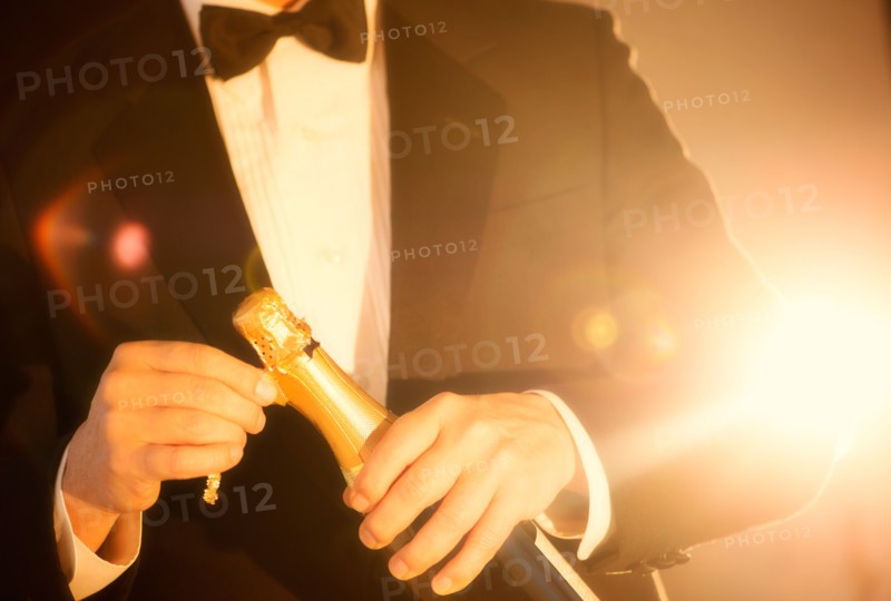Elegant man opening champagne.