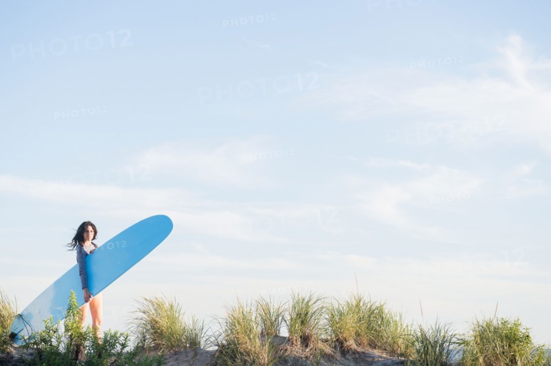 Female surfer walking on beach. Photo : Jamie Grill