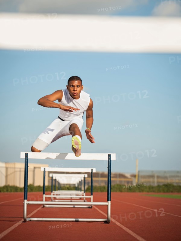 Boy (12-13) hurdling on running track. Photo: Erik Isakson