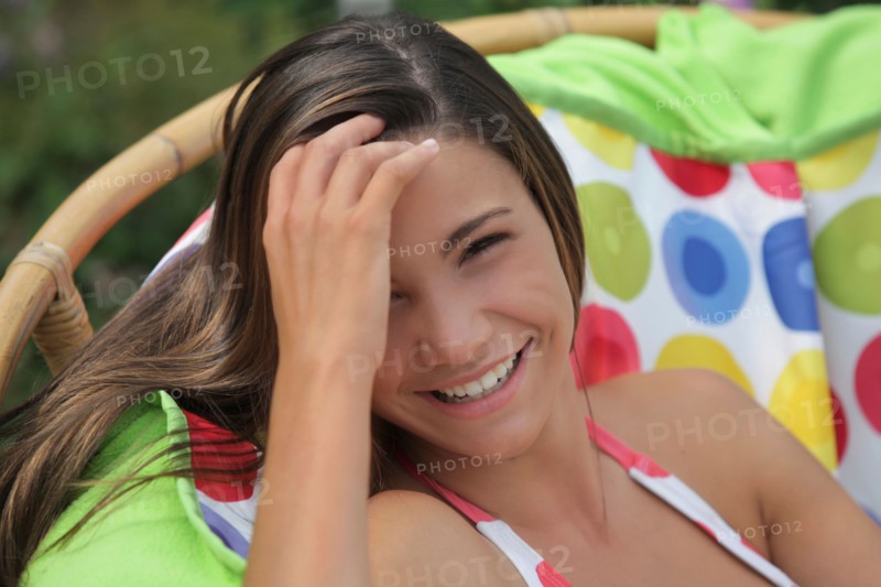Portrait of girl (12-13) in bikini relaxing in outdoor chair. Photo : pauline st.denis