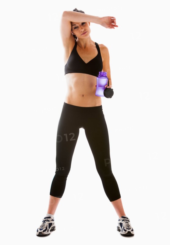 Young woman resting after exercising, studio shot. Photo : Mike Kemp