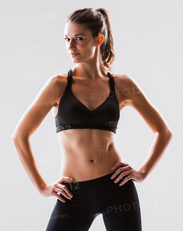 Portrait of young woman exercising, studio shot. Photo: Mike Kemp