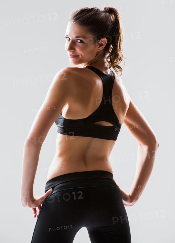 Portrait of young woman exercising, studio shot. Photo: Mike Kemp