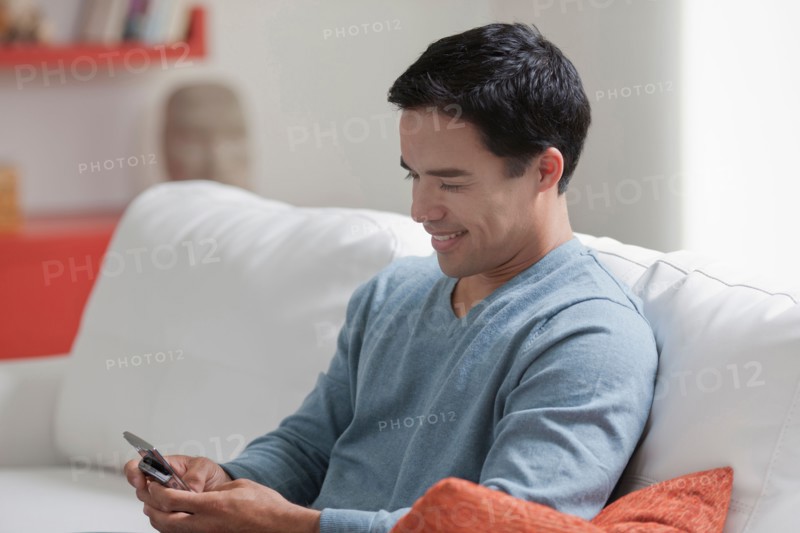 Man texting in living room. Photo: Dan Bannister