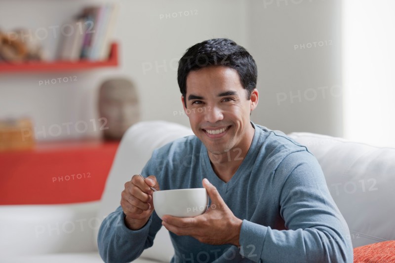 Portrait of man with bowl in living room. Photo: Dan Bannister