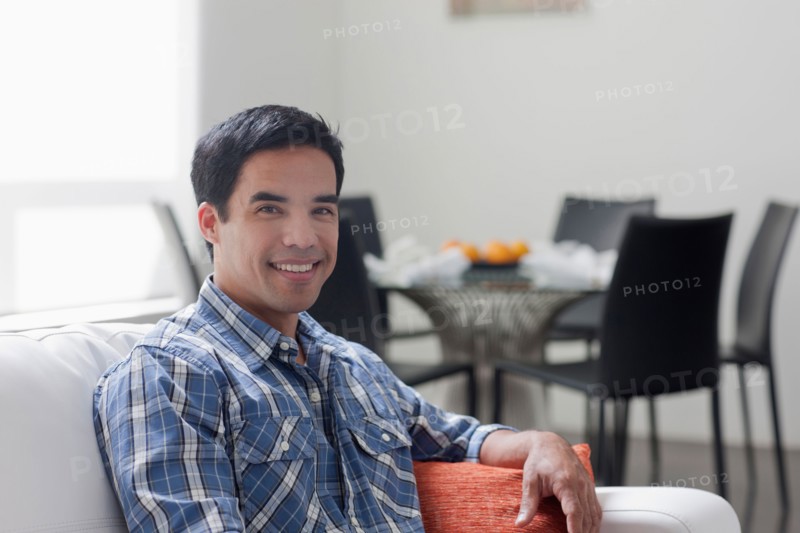Portrait of man sitting in living room. Photo: Dan Bannister