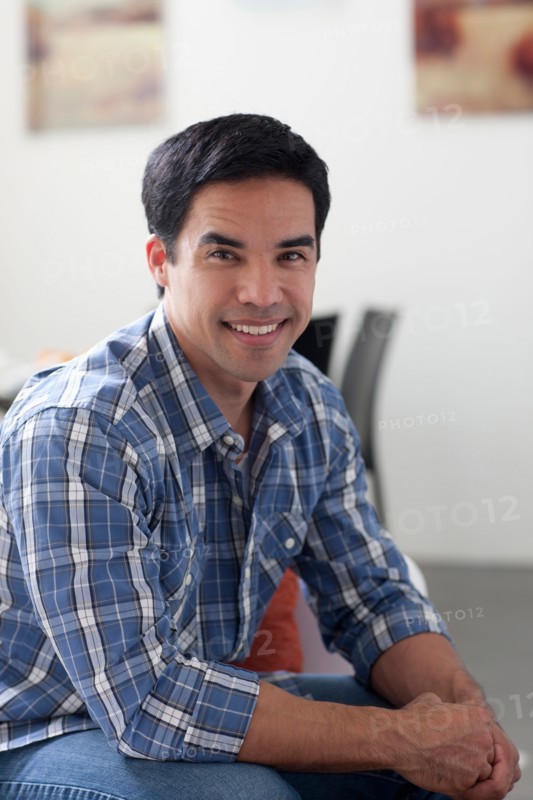 Portrait of man sitting in living room. Photo: Dan Bannister