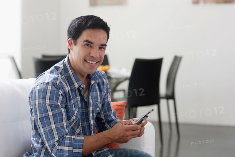Man texting in living room. Photo: Dan Bannister