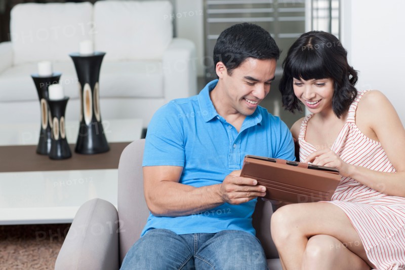 Young couple looking at photos. Photo : Dan Bannister