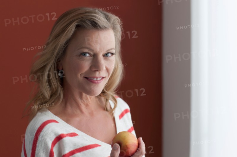 Portrait of mature woman eating apple. Photo: Dan Bannister