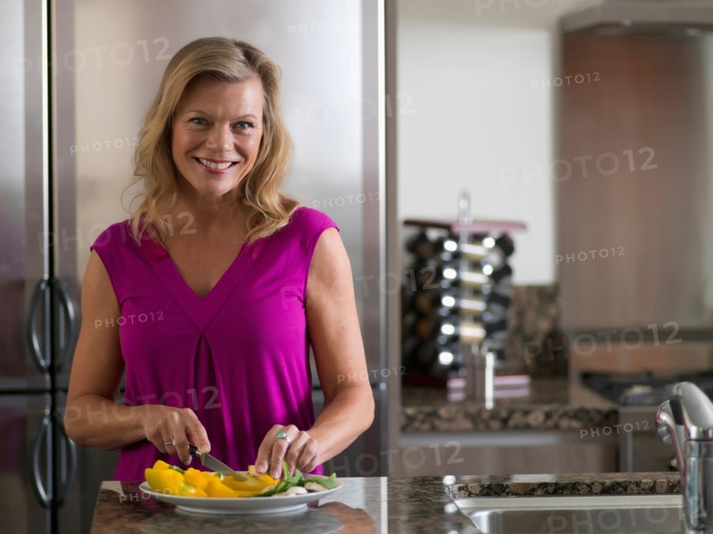 Portrait of mature woman preparing salad. Photo: Dan Bannister