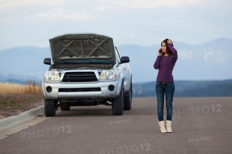 Woman calling for assistance after vehicle breakdown. Photo : Noah Clayton