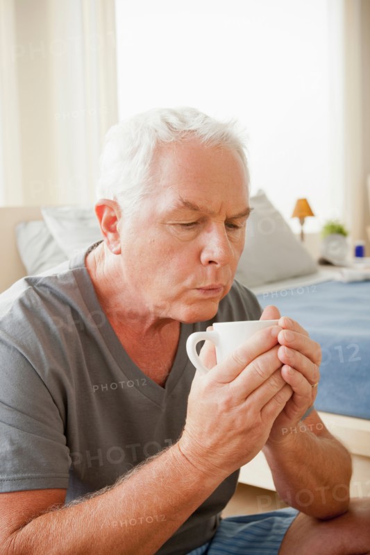 Senior man holding mug. Photo : Rob Lewine